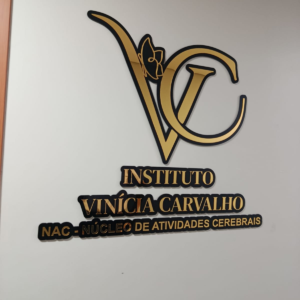 Letreiro interno em acrílico preto e dourado na parede de uma recepção
